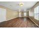 Empty living room with hardwood floors, neutral colored walls, and a white front door at 8604 Rockmoor Ridge Rd, Charlotte, NC 28215