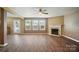 Open living area with a fireplace, windows, and door leading outside at 8604 Rockmoor Ridge Rd, Charlotte, NC 28215
