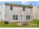 Rear exterior of the home featuring neutral siding, windows, and a small patio at 9236 Clifton Meadow Dr, Matthews, NC 28105