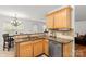 Well-lit kitchen featuring light wood cabinets, granite countertops, and stainless steel sink at 9236 Clifton Meadow Dr, Matthews, NC 28105