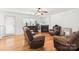 Bright living room featuring hardwood floors, fireplace, and comfortable brown leather seating at 9236 Clifton Meadow Dr, Matthews, NC 28105