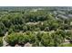 Expansive aerial view of lush community nestled among mature trees, with a community pool and ample parking at 9412 Rosalyn Glen Rd, Cornelius, NC 28031