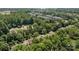An aerial view showing mature trees surround a community pool, apartment buildings, and charming single-Gathering homes at 9412 Rosalyn Glen Rd, Cornelius, NC 28031