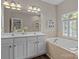 A luxurious bathroom features double sinks, a soaking tub, and stylish lighting fixtures at 9412 Rosalyn Glen Rd, Cornelius, NC 28031