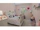 Charming bedroom with soft pink walls, a cute bed with a rainbow comforter and a window view at 9412 Rosalyn Glen Rd, Cornelius, NC 28031