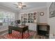 Well-lit home office with a large desk, built-in shelving and a view of the outside at 9412 Rosalyn Glen Rd, Cornelius, NC 28031