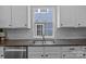 A kitchen features a stainless steel sink, granite countertops and subway tile backsplash at 9412 Rosalyn Glen Rd, Cornelius, NC 28031