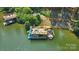 Aerial view showcasing a house boat on the lake with a slide, outdoor seating, and lush greenery at 10043 Tepa Pl, Tega Cay, SC 29708