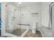 Bathroom showcasing a glass shower with tile surround, bench, and sleek fixtures at 10043 Tepa Pl, Tega Cay, SC 29708