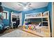 Charming bedroom with colorful bunk beds, a desk, white rug, and hardwood flooring at 10043 Tepa Pl, Tega Cay, SC 29708