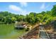 Spacious boat dock with boat and lake access, surrounded by a wooded shoreline on a sunny day at 10043 Tepa Pl, Tega Cay, SC 29708