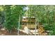 Exterior view of a multi-level home with wooden decks and stairs, nestled among mature trees at 10043 Tepa Pl, Tega Cay, SC 29708