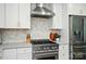 Updated kitchen featuring stainless steel appliances, a decorative backsplash, and modern white cabinetry at 10043 Tepa Pl, Tega Cay, SC 29708