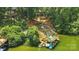Aerial view of a lake house and dock with stairs, slide, and boat lifts surrounded by dense trees at 10043 Tepa Pl, Tega Cay, SC 29708