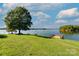 Picturesque view of a lake with grassy area, shade tree, a viewing platform, and peaceful water at 10043 Tepa Pl, Tega Cay, SC 29708