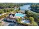 Aerial view of a luxurious community swimming pool, sun deck, and lake access, all surrounded by lush landscaping at 10043 Tepa Pl, Tega Cay, SC 29708