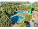 Overhead view of a tennis court complex nestled among green trees, featuring multiple blue courts at 10043 Tepa Pl, Tega Cay, SC 29708