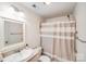 Clean bathroom featuring a vanity sink, toilet, and shower with a neutral-toned curtain at 10127 Tallent Ln, Huntersville, NC 28078