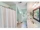 Bright, vaulted bathroom features a white shower curtain and a large vanity at 10127 Tallent Ln, Huntersville, NC 28078