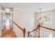 Upstairs hallway with hardwood floors, white trim, and wrought iron chandelier at 10127 Tallent Ln, Huntersville, NC 28078