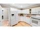 Well-lit kitchen featuring white appliances, ample cabinet space, and wood-look flooring at 10127 Tallent Ln, Huntersville, NC 28078