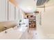 Functional laundry room with modern appliances, ample cabinet space, and shelving for organized storage at 10127 Tallent Ln, Huntersville, NC 28078