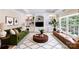 Bright living room with a green sofa, custom built-in shelving, and large window at 10127 Tallent Ln, Huntersville, NC 28078