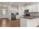 Updated kitchen with stainless steel refrigerator, white cabinets, subway tile backsplash, and granite countertops at 10410 Bradstreet Commons Way, Charlotte, NC 28215