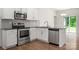 Charming Kitchen with white cabinets, stainless steel appliances, and hardwood floors at 10410 Bradstreet Commons Way, Charlotte, NC 28215