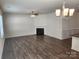 Bright living room with hardwood floors, a cozy fireplace, and a modern ceiling fan at 10410 Bradstreet Commons Way, Charlotte, NC 28215