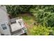 A backyard with a deck featuring a hot tub and lounge area, bordered by trees and lawn at 108 Shade Tree Cir, Fort Mill, SC 29715
