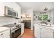 Bright kitchen features stainless steel appliances, white cabinets, and convenient laundry access at 108 Shade Tree Cir, Fort Mill, SC 29715
