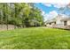 Expansive backyard with lush green lawn, mature trees, and a secluded patio area, great for outdoor activities at 10951 Fox Mill Ln, Charlotte, NC 28277