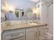 Bright bathroom features a dual vanity with granite countertop, tiled shower, and elegant lighting at 11120 Sevilla Ct, Charlotte, NC 28226