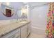 Well-lit bathroom with white subway tile shower, granite vanity, and patterned shower curtain, creating a fresh space at 11120 Sevilla Ct, Charlotte, NC 28226
