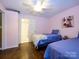 Cozy bedroom with two twin beds, light pink walls, and hardwood floors, perfect for a comfortable stay at 11120 Sevilla Ct, Charlotte, NC 28226