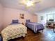 Attic bedroom with hardwood floors, ceiling fan, and two twin beds at 11120 Sevilla Ct, Charlotte, NC 28226