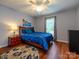 Cozy bedroom with hardwood floors, ceiling fan, and serene blue bedding at 11120 Sevilla Ct, Charlotte, NC 28226