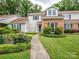 Charming brick and siding home with manicured front yard, lush landscaping, and a welcoming walkway at 11120 Sevilla Ct, Charlotte, NC 28226