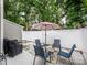 Patio with outdoor seating, a striped umbrella, and a white privacy fence, ideal for relaxing outdoors at 11120 Sevilla Ct, Charlotte, NC 28226