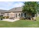 Charming backyard with outdoor patio, table, and umbrella; lush green lawn surrounded by landscaping at 112 E Neel Ranch Rd, Mooresville, NC 28115