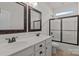 Bathroom featuring double sinks, framed mirrors, and a glass-enclosed shower for a modern touch at 112 E Neel Ranch Rd, Mooresville, NC 28115