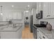 Bright kitchen boasts granite countertops, stainless steel appliances, and stylish white cabinetry at 112 E Neel Ranch Rd, Mooresville, NC 28115