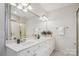 Bathroom featuring a double sink vanity and a framed mirror with sconce lighting at 11234 Villa Trace Pl, Charlotte, NC 28277