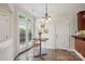 Cozy breakfast nook with tiled floors, round table, three stools, and door to outside at 11234 Villa Trace Pl, Charlotte, NC 28277