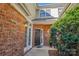 Welcoming entrance with brick exterior, a black door with decorative wreath, and beautiful sidelights at 11234 Villa Trace Pl, Charlotte, NC 28277