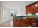 Kitchen with dark granite countertops, cherry cabinets, and bright breakfast nook at 11234 Villa Trace Pl, Charlotte, NC 28277