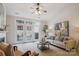 Inviting living room featuring a cozy sofa, large windows with door to outside and a ceiling fan at 11234 Villa Trace Pl, Charlotte, NC 28277