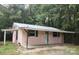 Cozy single-story home with a metal roof, covered porch, and green shutters surrounded by lush greenery at 11550 Us Hwy 52 N Hwy, Ansonville, NC 28170