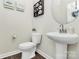 Stylish half bathroom with a pedestal sink, modern toilet, and decorative wall art at 11733 Mesquite Rd, Huntersville, NC 28078